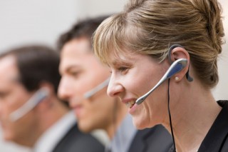 Happy co-workers in headsets working in call center